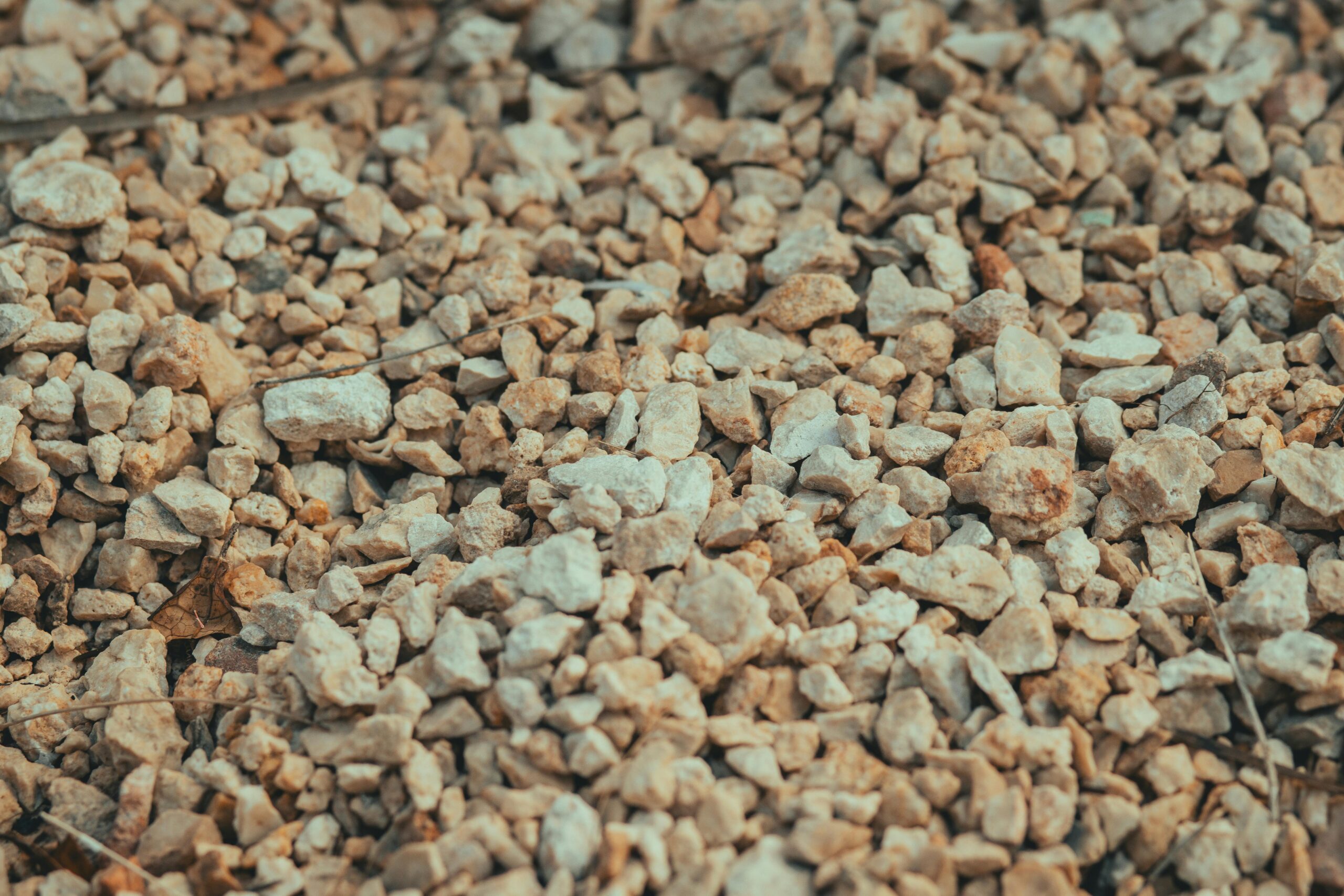 High-Purity Natural Gypsum A detailed view of beige gravel, showcasing natural stone texture and surface.
