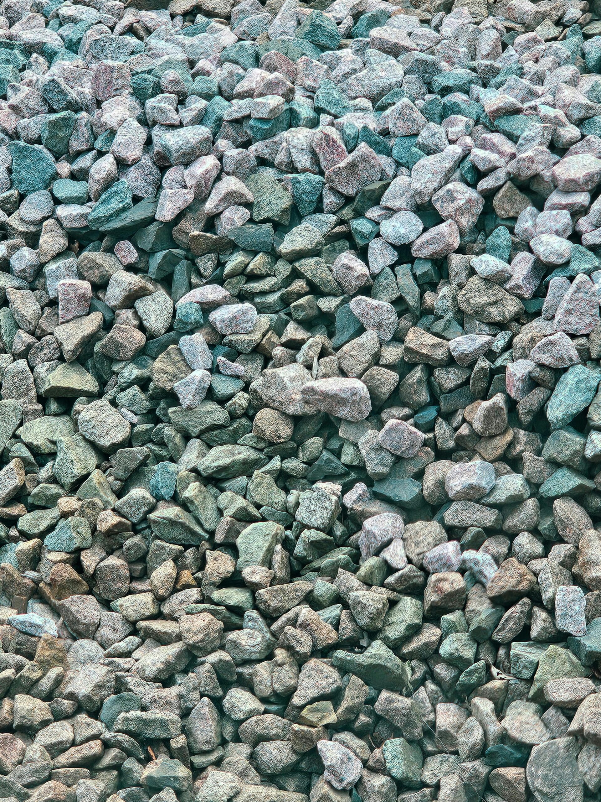 High-Purity Natural Gypsum Close-up view of natural stones and pebbles forming a textured background, showcasing erosion and variation in color.