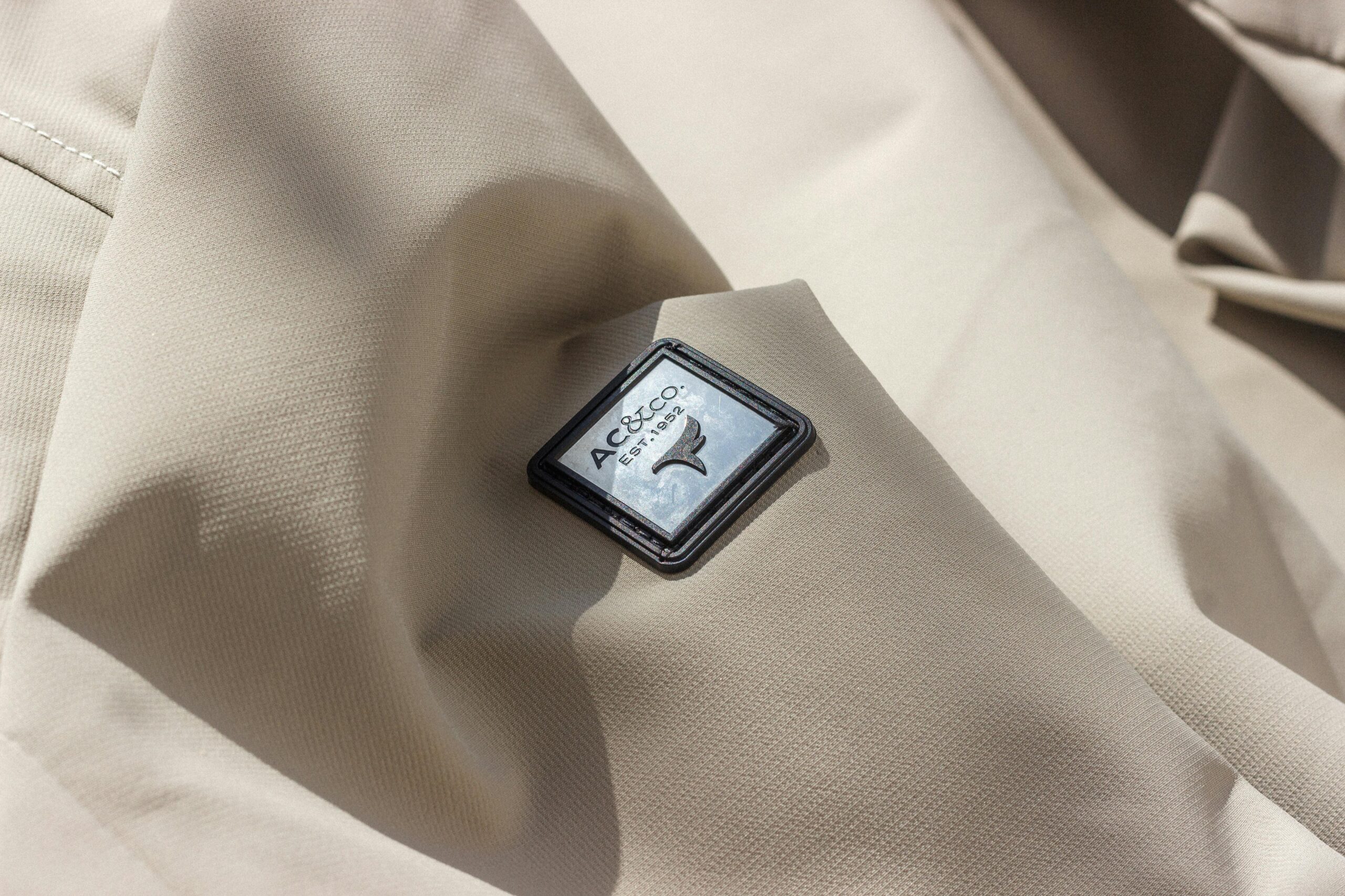 High-Grade Fabric & Textile Close-up of beige fabric showcasing AC&Co logo, perfect for fashion content.