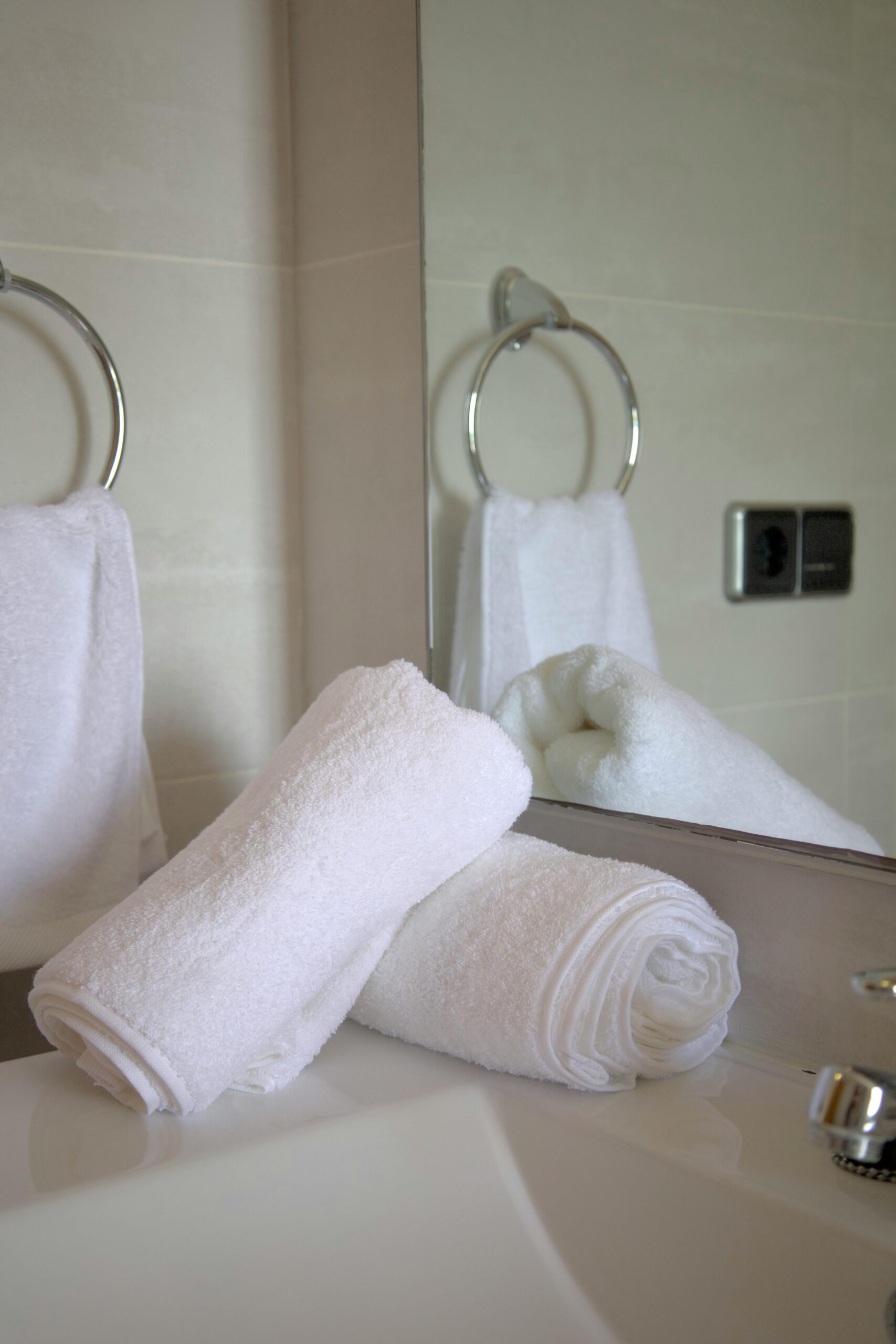 High-Absorbency Luxury Towels Pristine white towels neatly arranged in a stylish bathroom setting.