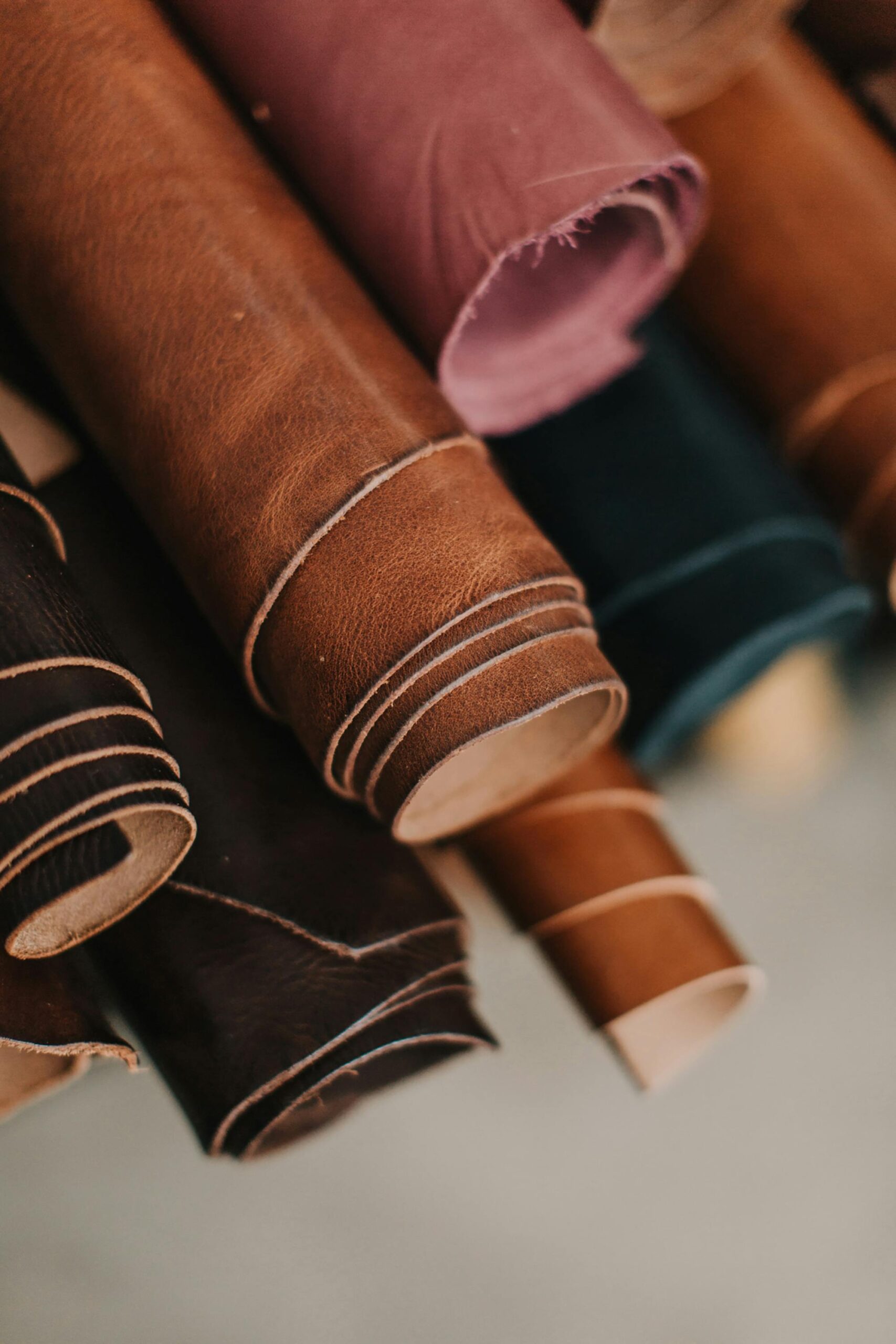 premium finished cow leather Close-up of assorted multicolored leather rolls in a craftsman workshop setting.