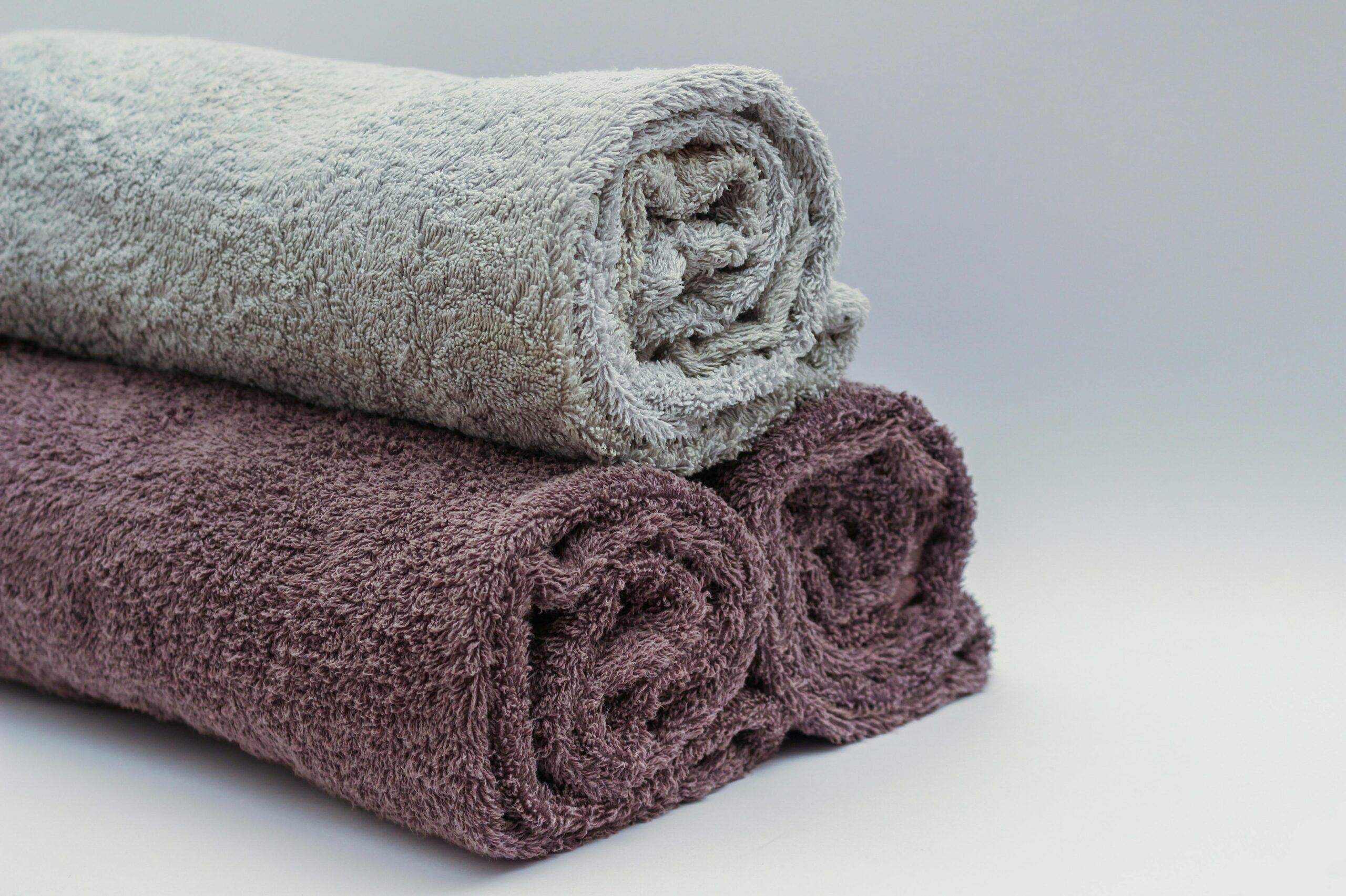High-Absorbency Luxury Towels Close-up of rolled bathroom towels in neutral tones, ideal for interior design or spa themes.