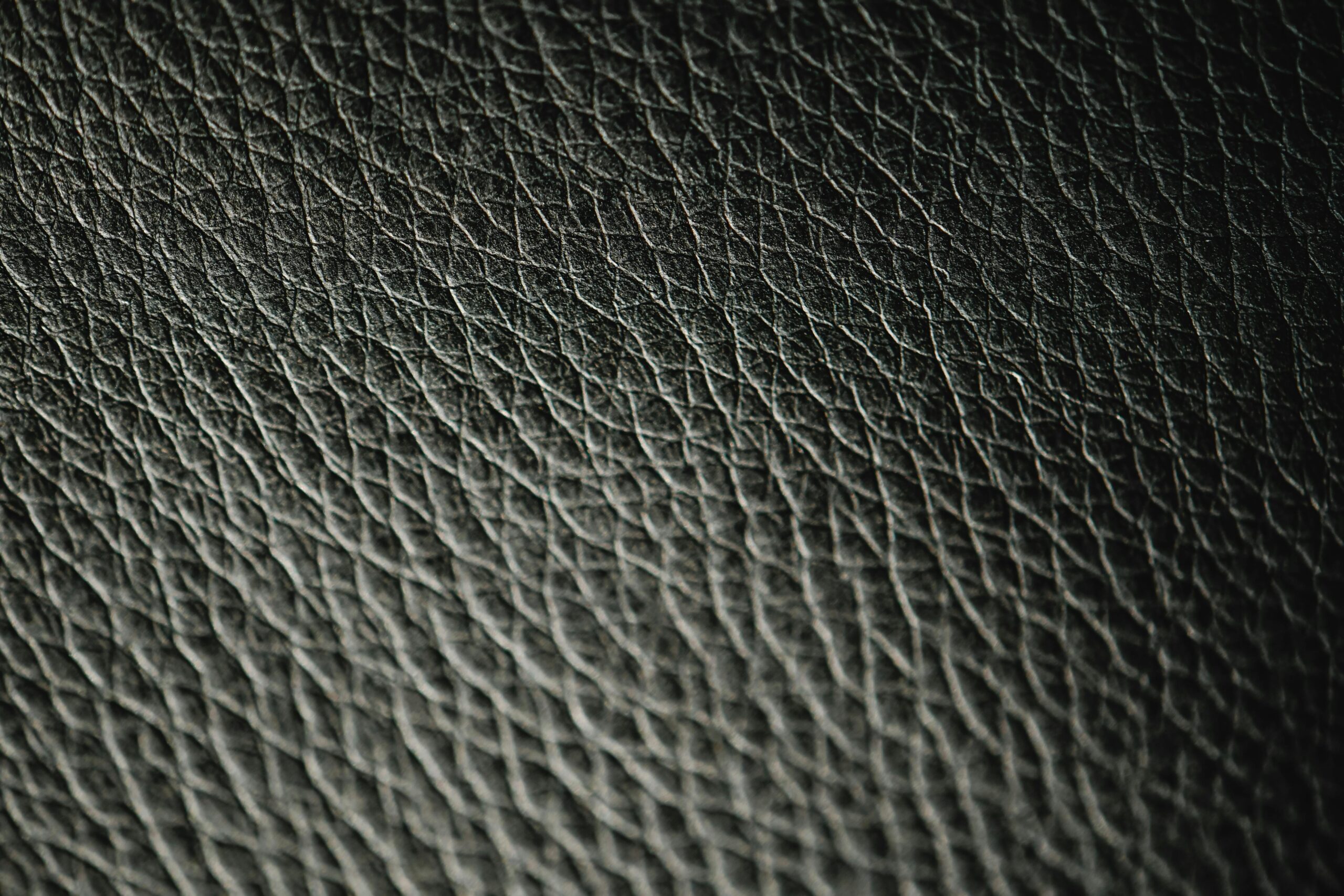 premium finished cow leather Macro photograph showcasing the intricate texture and pattern of black leather.