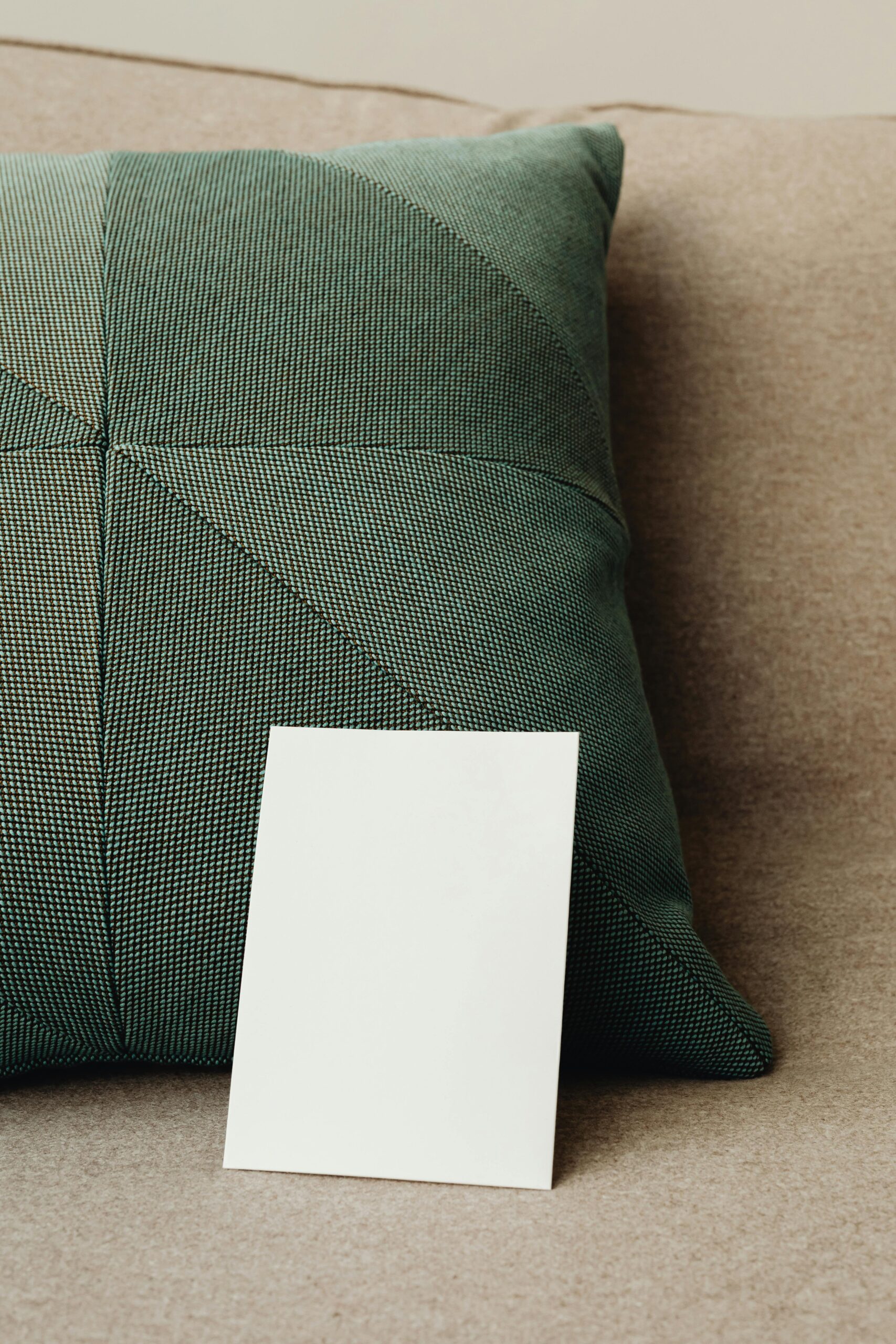 Premium Pillow Covers & Luxury Bedding Elegant throw pillow with blank paper on a sofa, perfect for mockups and design presentations.